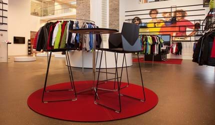 Rødt, rundt filtttæppe i showroom